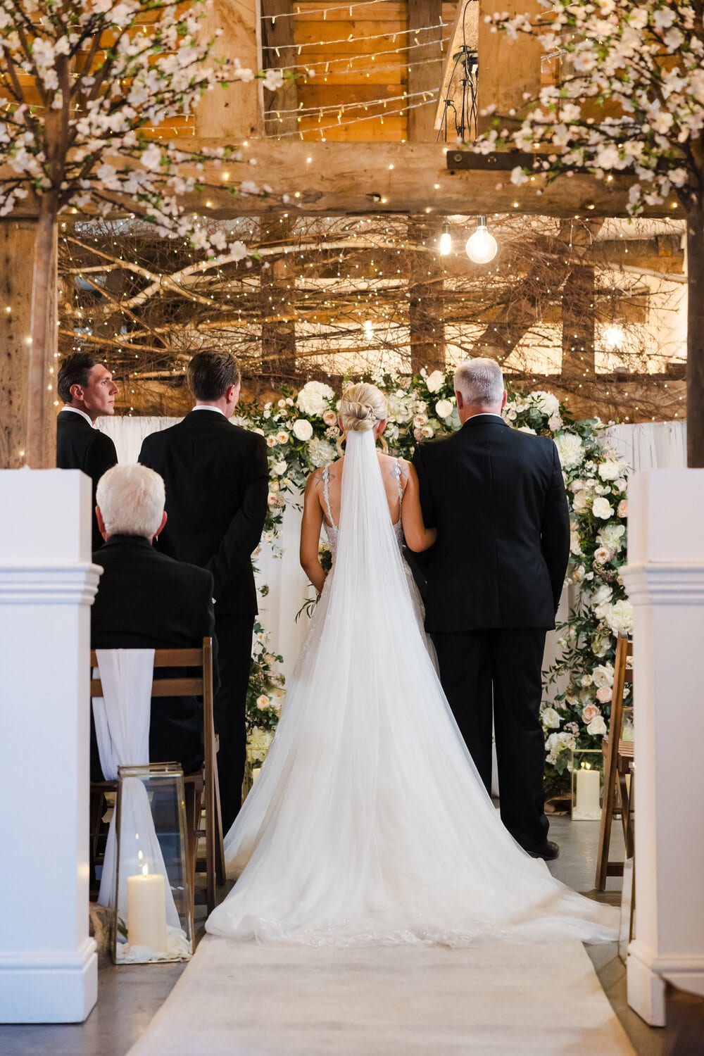 A couple at the altar with guests gathered in the Apple Barn