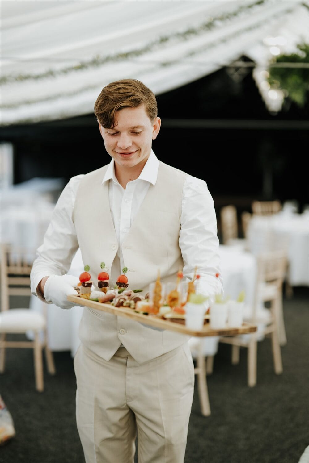 A waiter serving canapés at a reception in the Arboretum