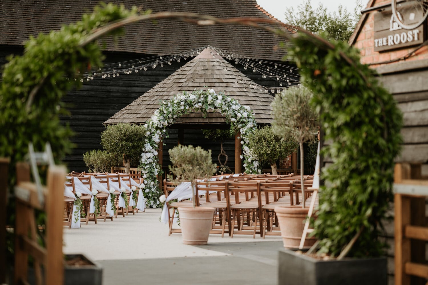 A circular floral moongate and chairs in the courtyard at The BarnYard