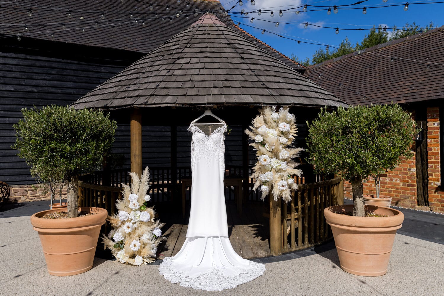A draped floral arch in the open-air courtyard at The BarnYard