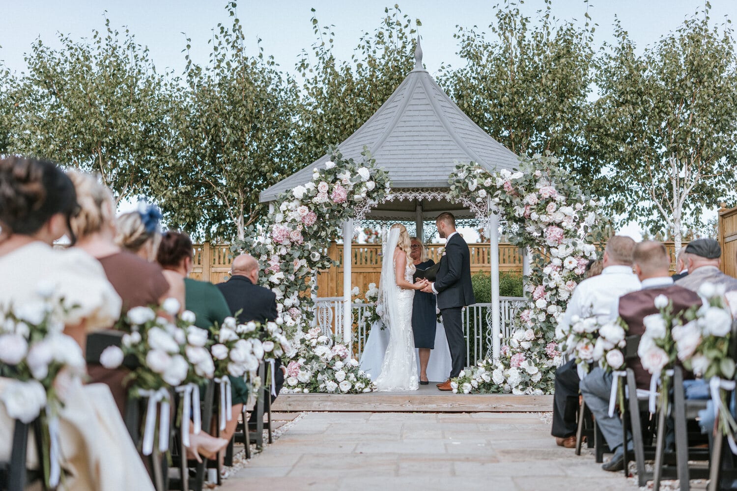 A couple at the lavender walk gazebo dressed with greenery and flowers