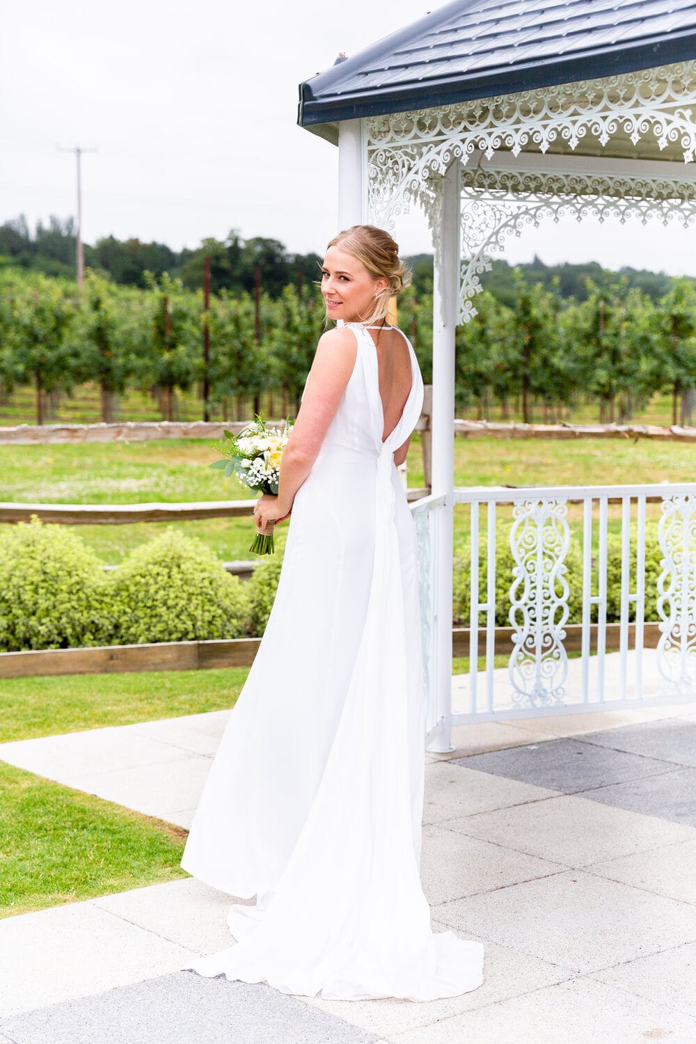 A bride walking towards the gazebo in the Orchard Garden