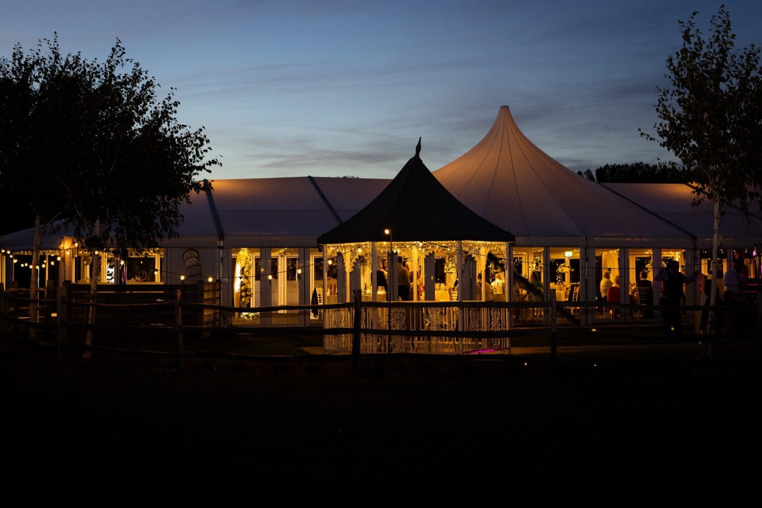 The Arboretum glass marquee glowing with fairy lights at dusk